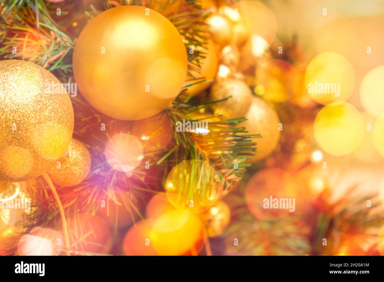 Decorated with golden Christmas balls on a blurred and sparkling light background  Stock Photo
