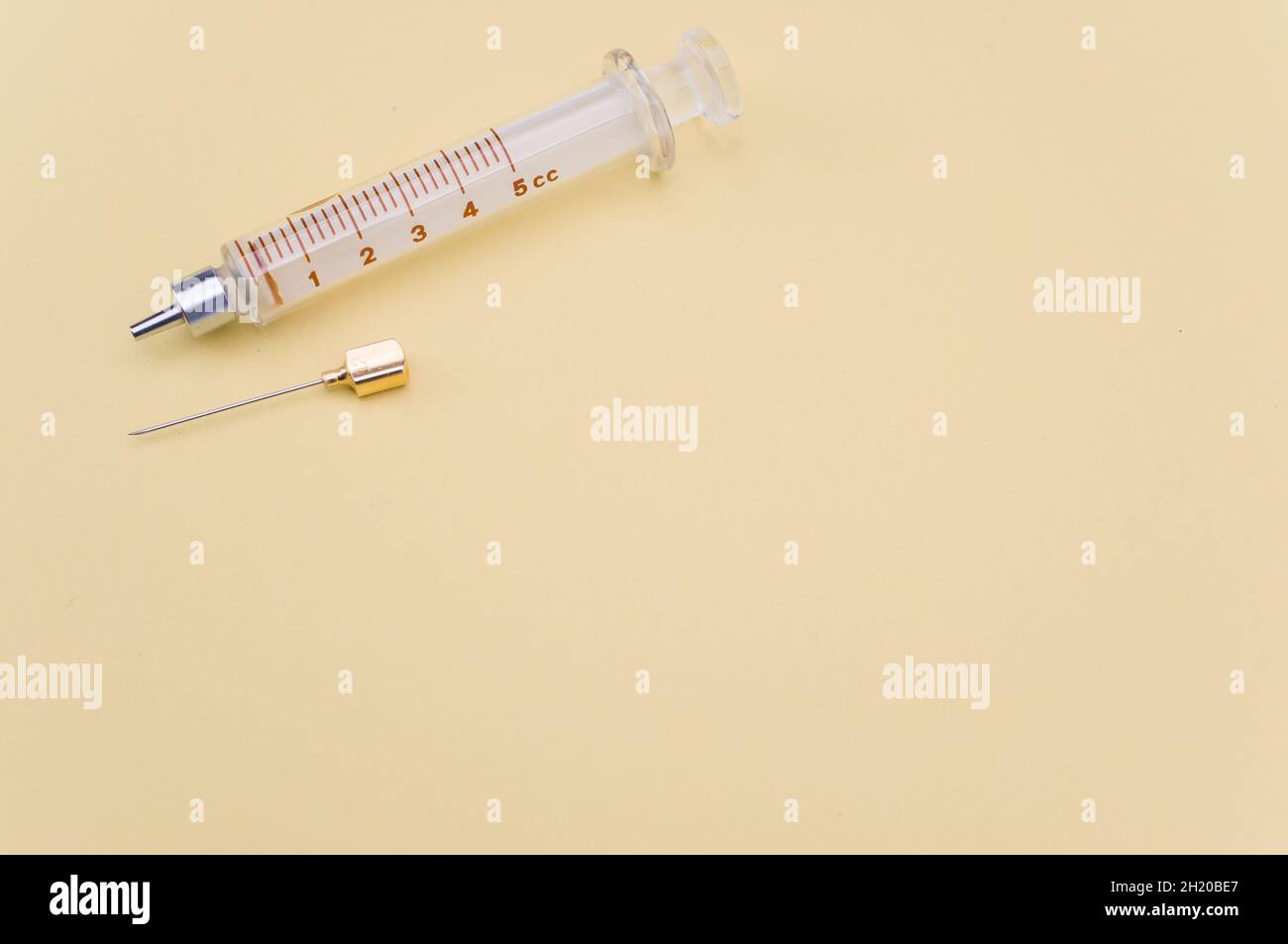 Touching Glass Injection isolated sterilized glass injection syringe on a yellow paper ...
