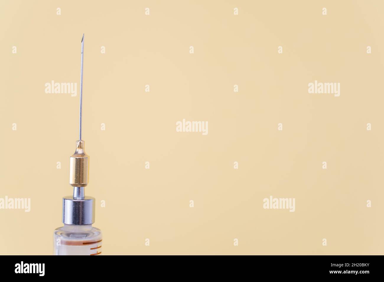 isolated sterilized glass injection syringe on a yellow paper