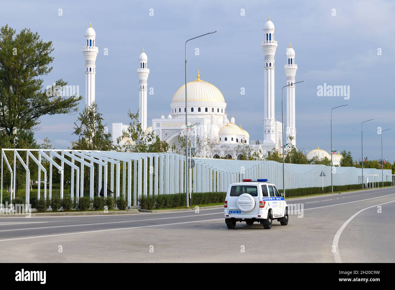 SHALI, RUSSIA - SEPTEMBER 29, 2021: Police car UAZ-Patriot against the background of the mosque 'Pride of Muslims' September morning Stock Photo