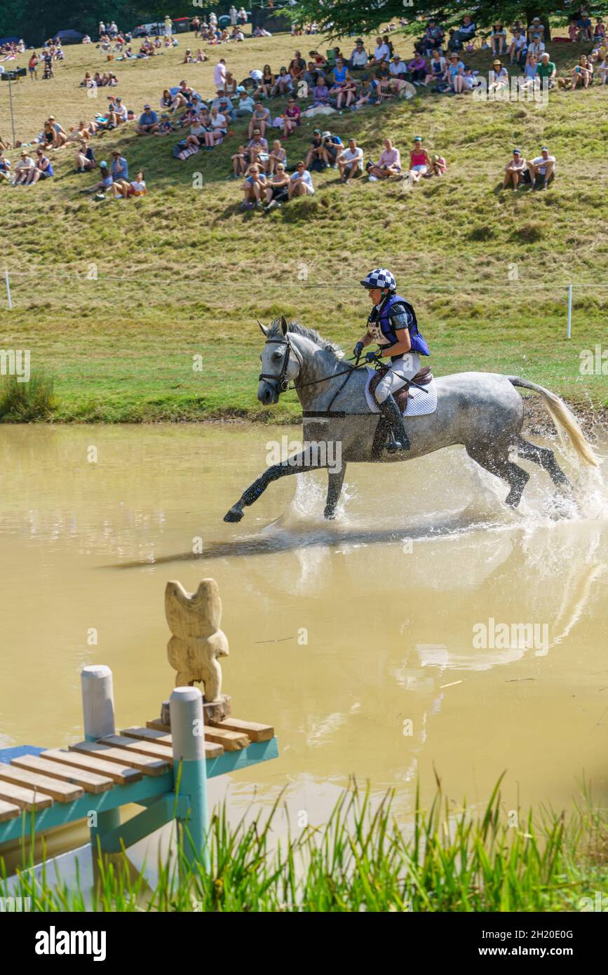 Horse and rider takling the cross country course and water jumps at an eventing competition in Gloucestershire, UK, in 2018. Stock Photo