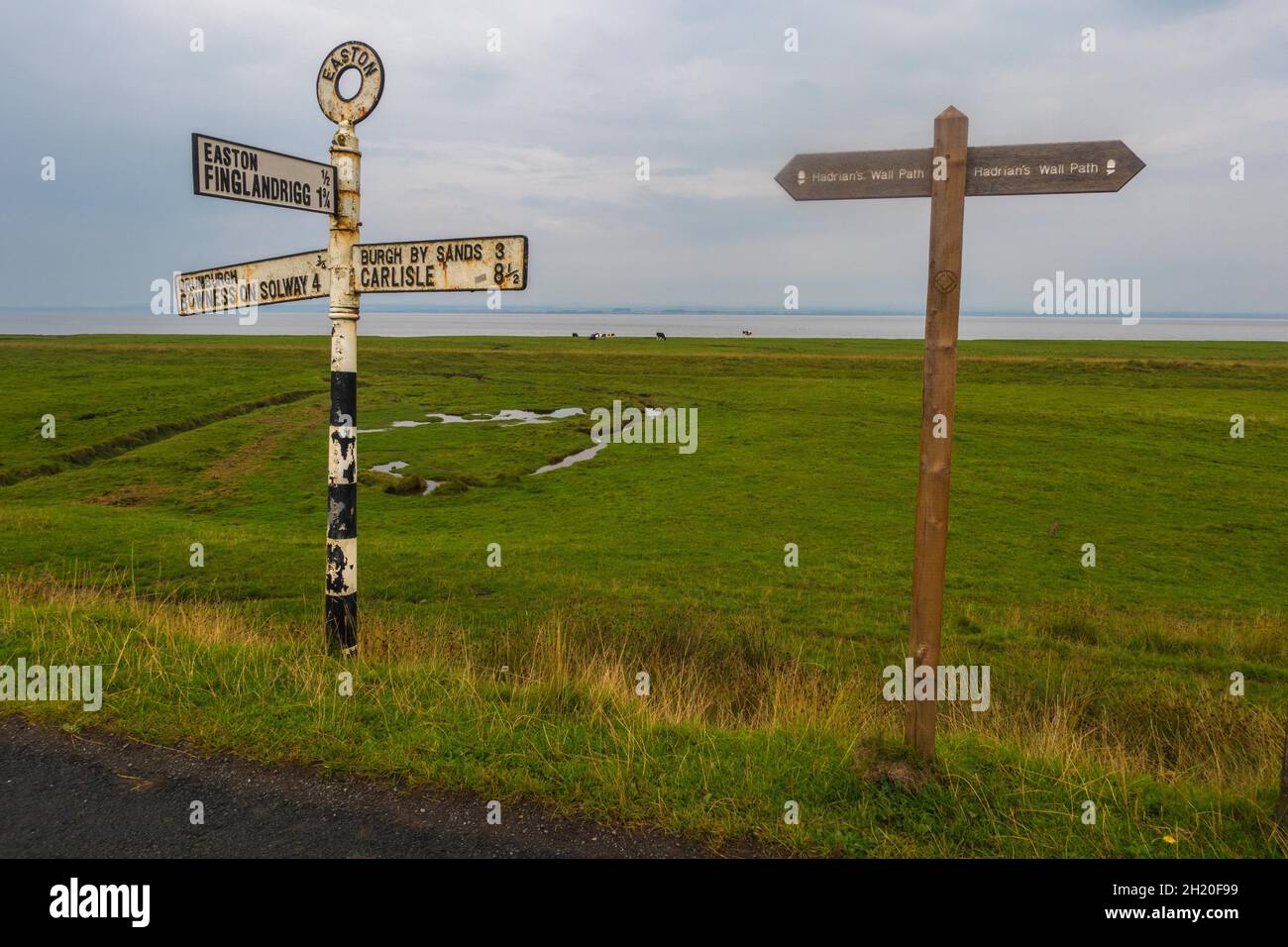 Signposts on Easton Marsh in Cumbria on the Hadrians Path route , a salt marsh east of Drumburgh looking across the Solway Firth to Scotland Stock Photo