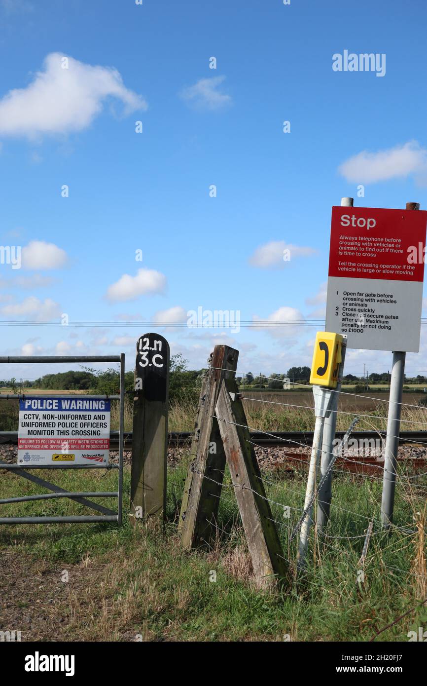 Warning signs on unmanned Railway crossing signs where vehicle and other users must telephone to check if they have time to cross safely. Stock Photo