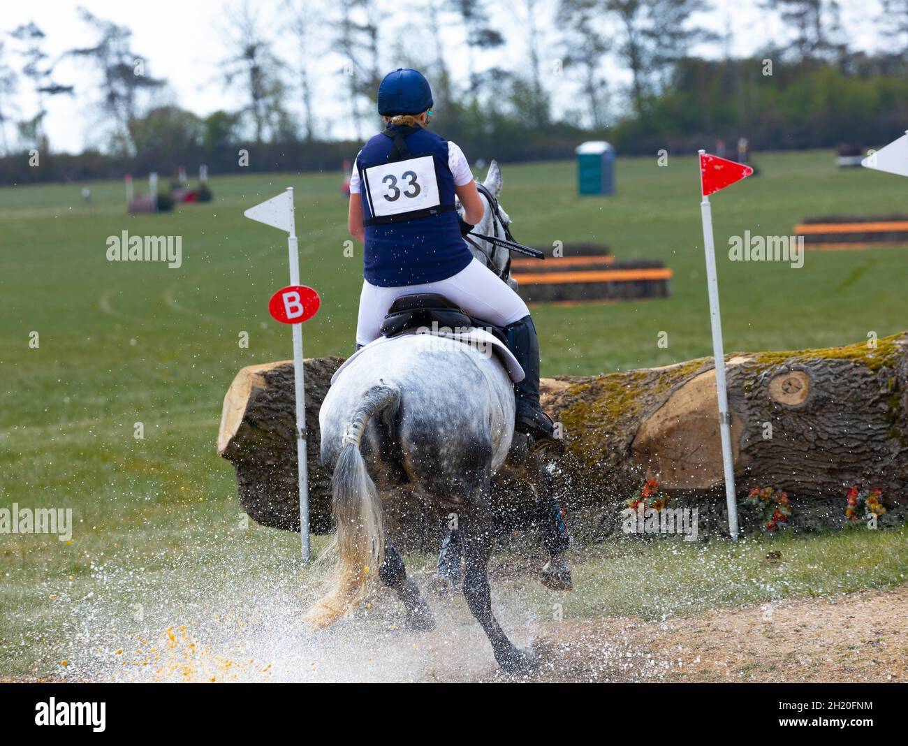 Event horse and rider jumping out of water at British Eventing at Horseheath Cambridgeshire England Stock Photo