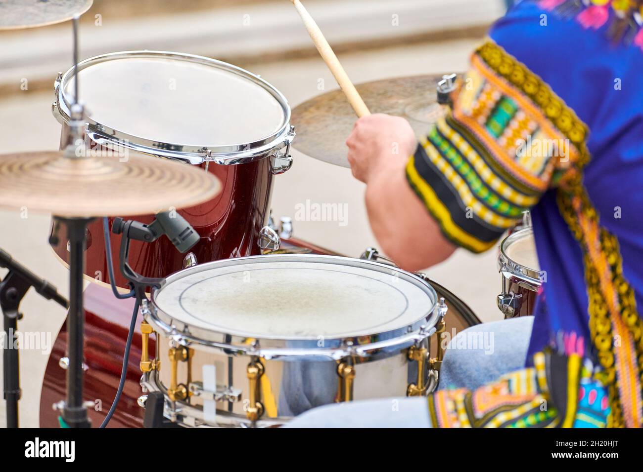 Drummer playing musical percussion instrument drums with sticks