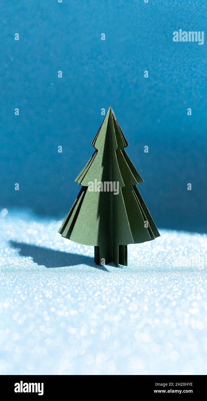 Christmas tree made of paper on a shiny blue background. Crafts by hand ...