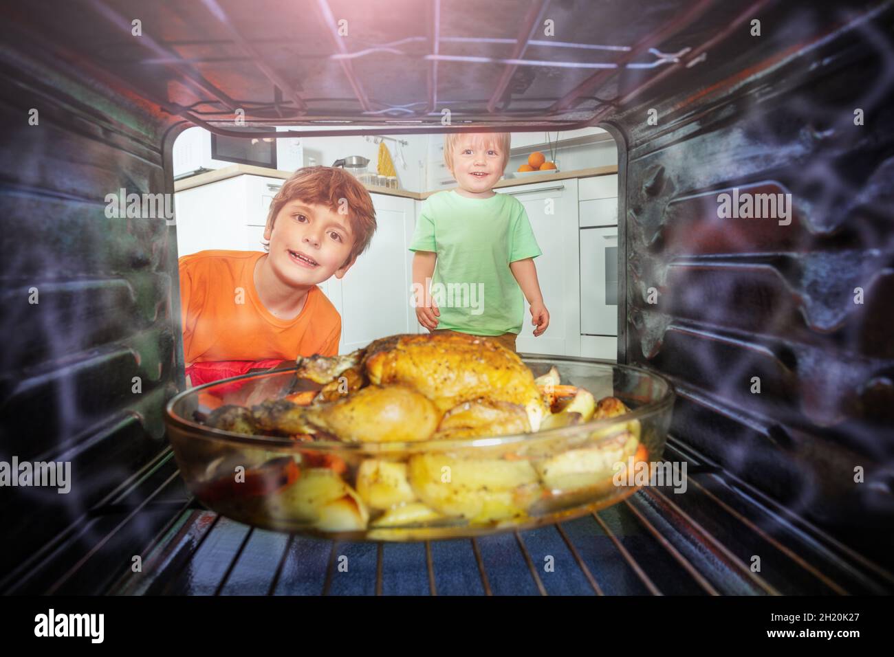 Two brothers open oven to take fried chicken Stock Photo Alamy