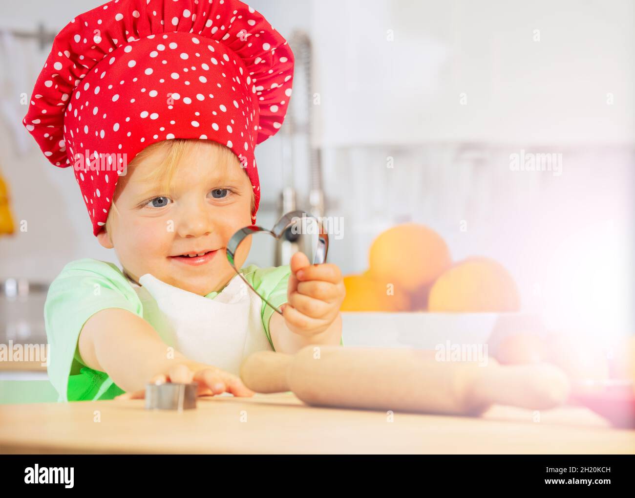 Child show heart shaped form baking at kitchen Stock Photo