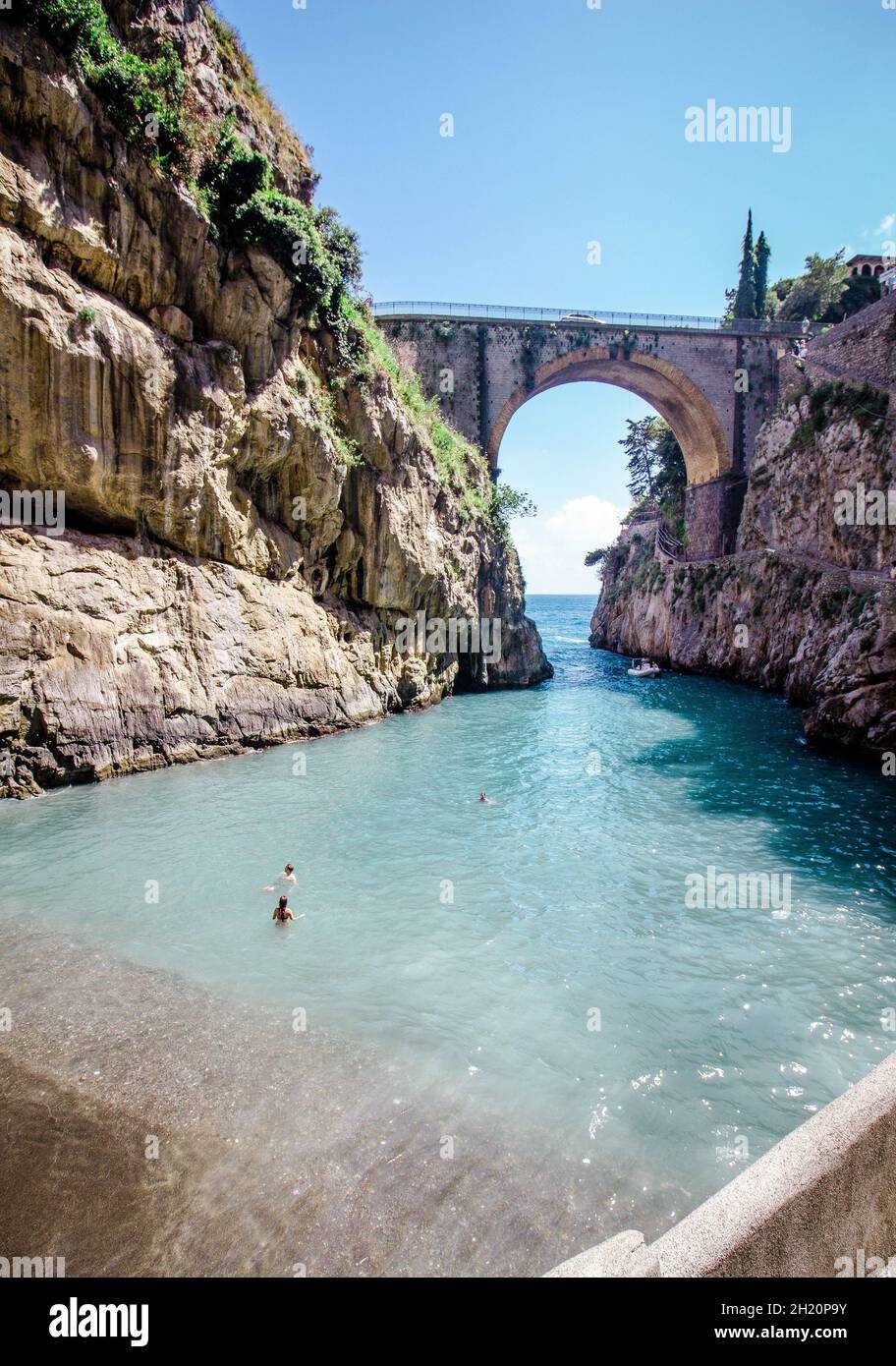 Fiordo di Furore is an arched stone bridge crosses this striking gorge with a tiny, rocky beach at its base. Stock Photo