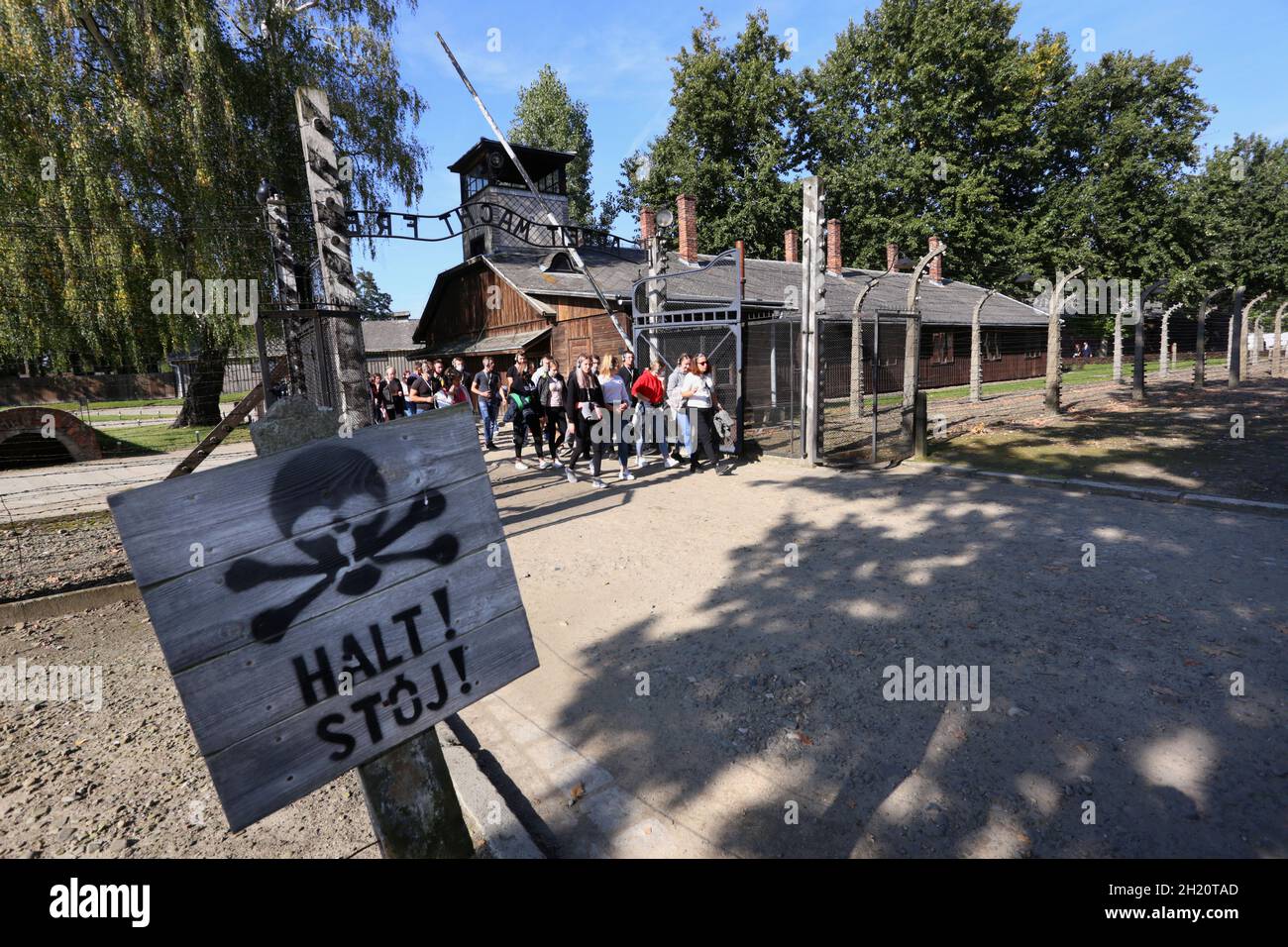 Oswiecim. Poland. Auschwitz-Birkenau, former Auschwitz Nazi death camp in Oswiecim. Poland. Tourists coming in through the 'Arbeit macht frei' gate. Stock Photo