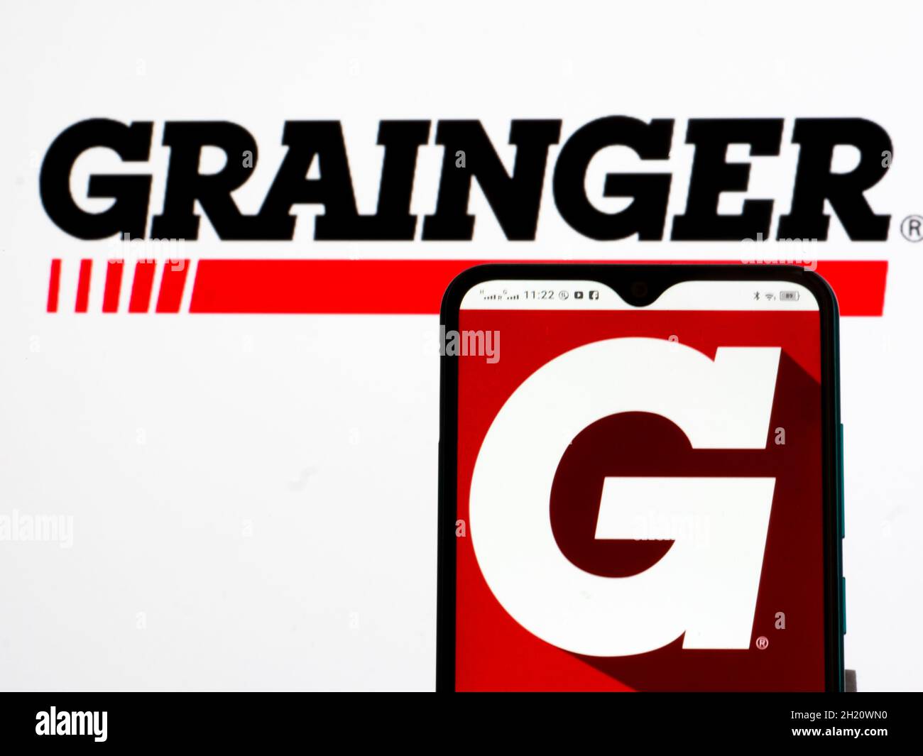 In this photo illustration, W. W. Grainger, Inc. logo seen displayed on a  smartphone and in the background Stock Photo - Alamy