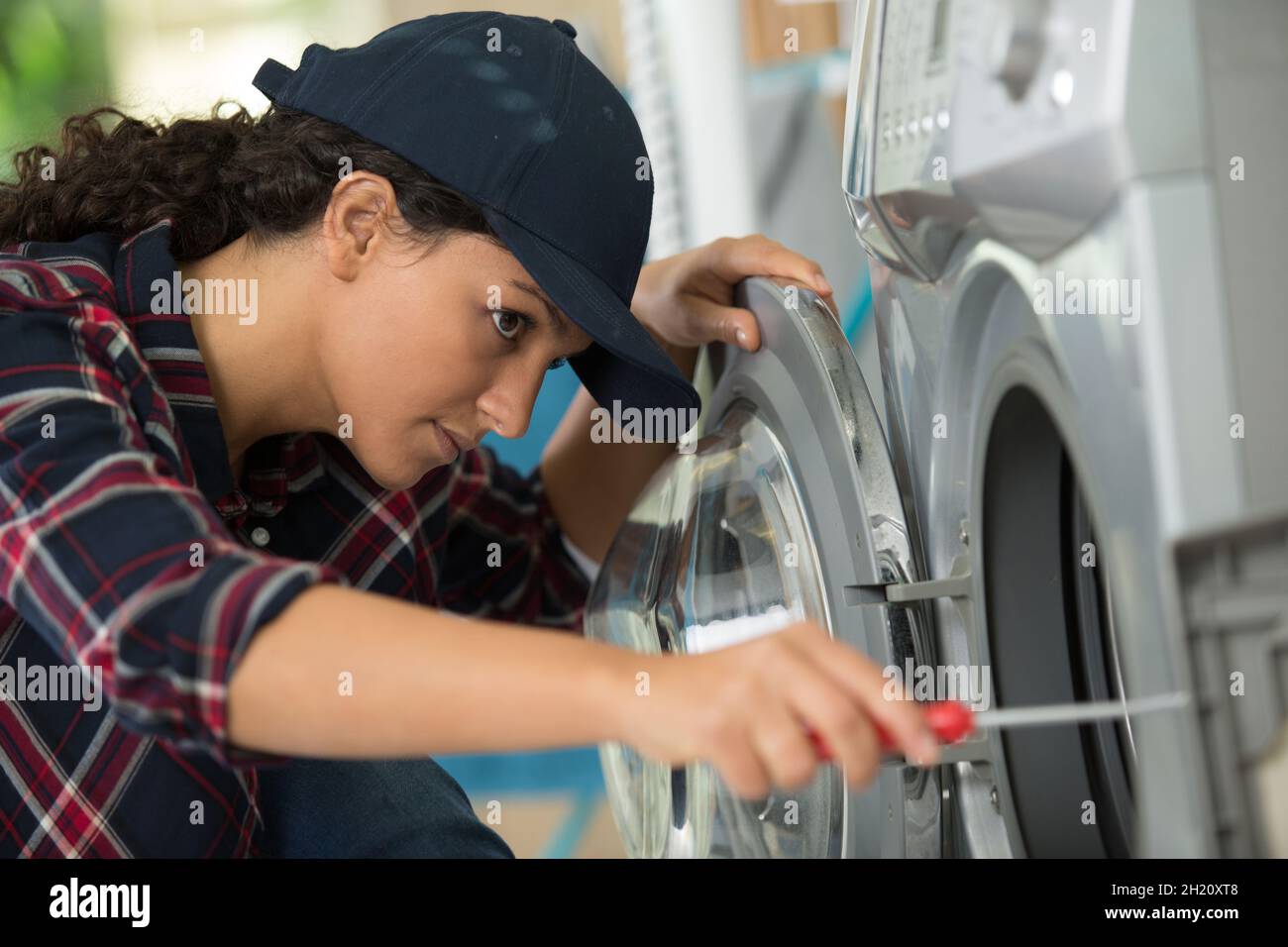 female plumber checking a washing machine Stock Photo Alamy