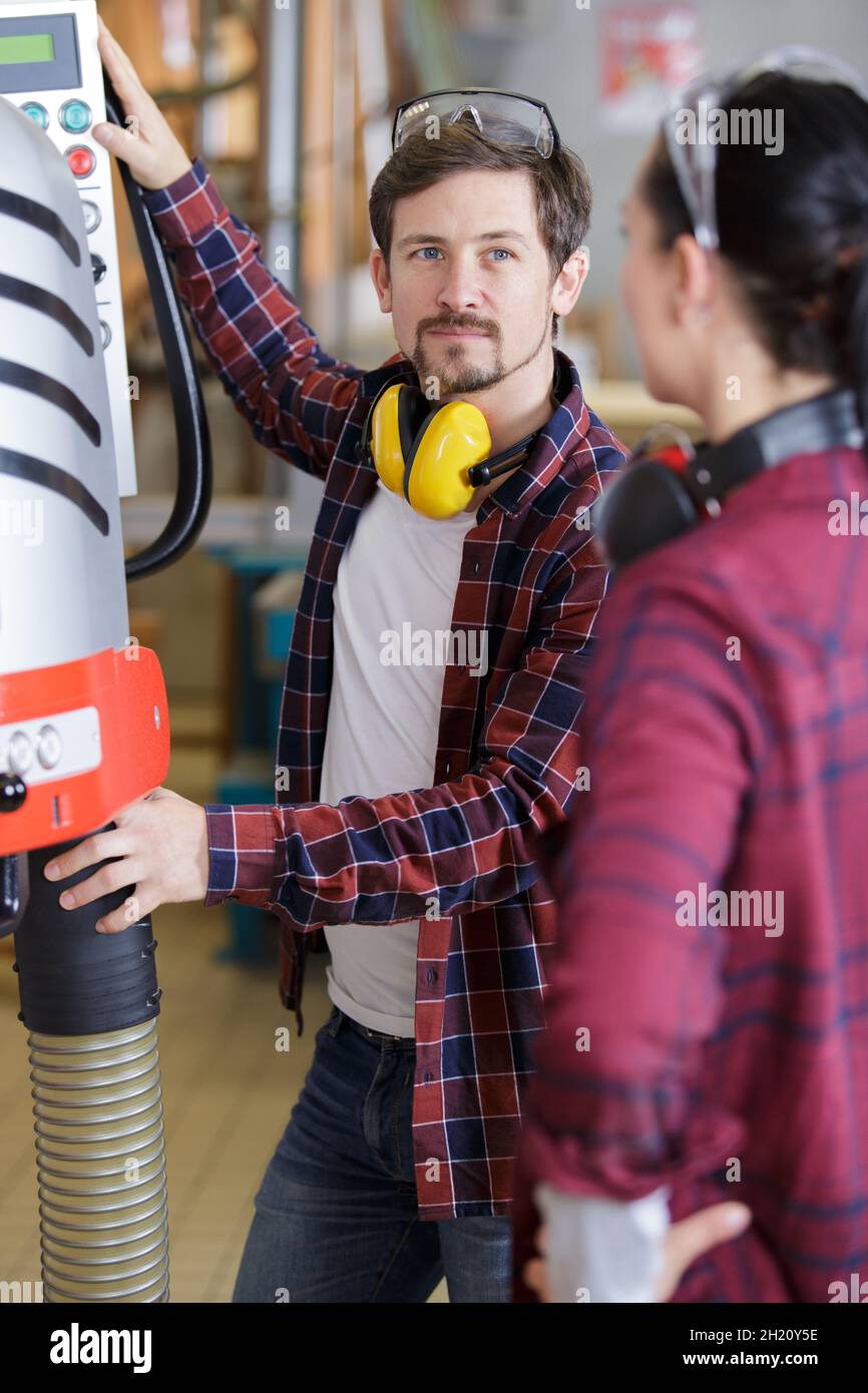 engineer training female apprentice on machine Stock Photo