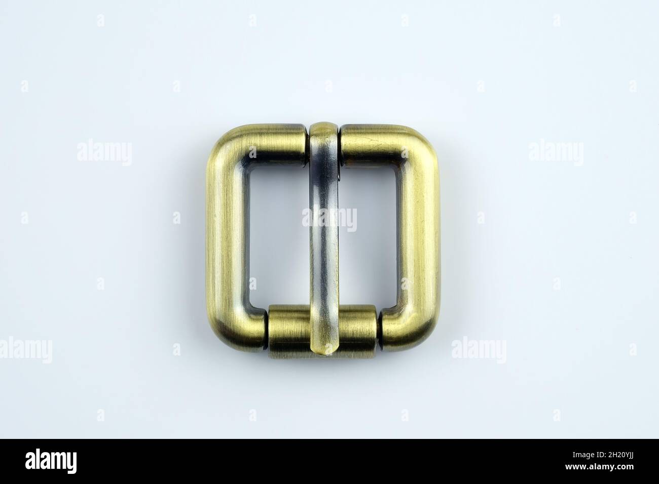 Square bronze  buckle with a flat tongue on a white background. Metal hardware for the manufacture of belts. High quality sewing accessories. Bag buck Stock Photo