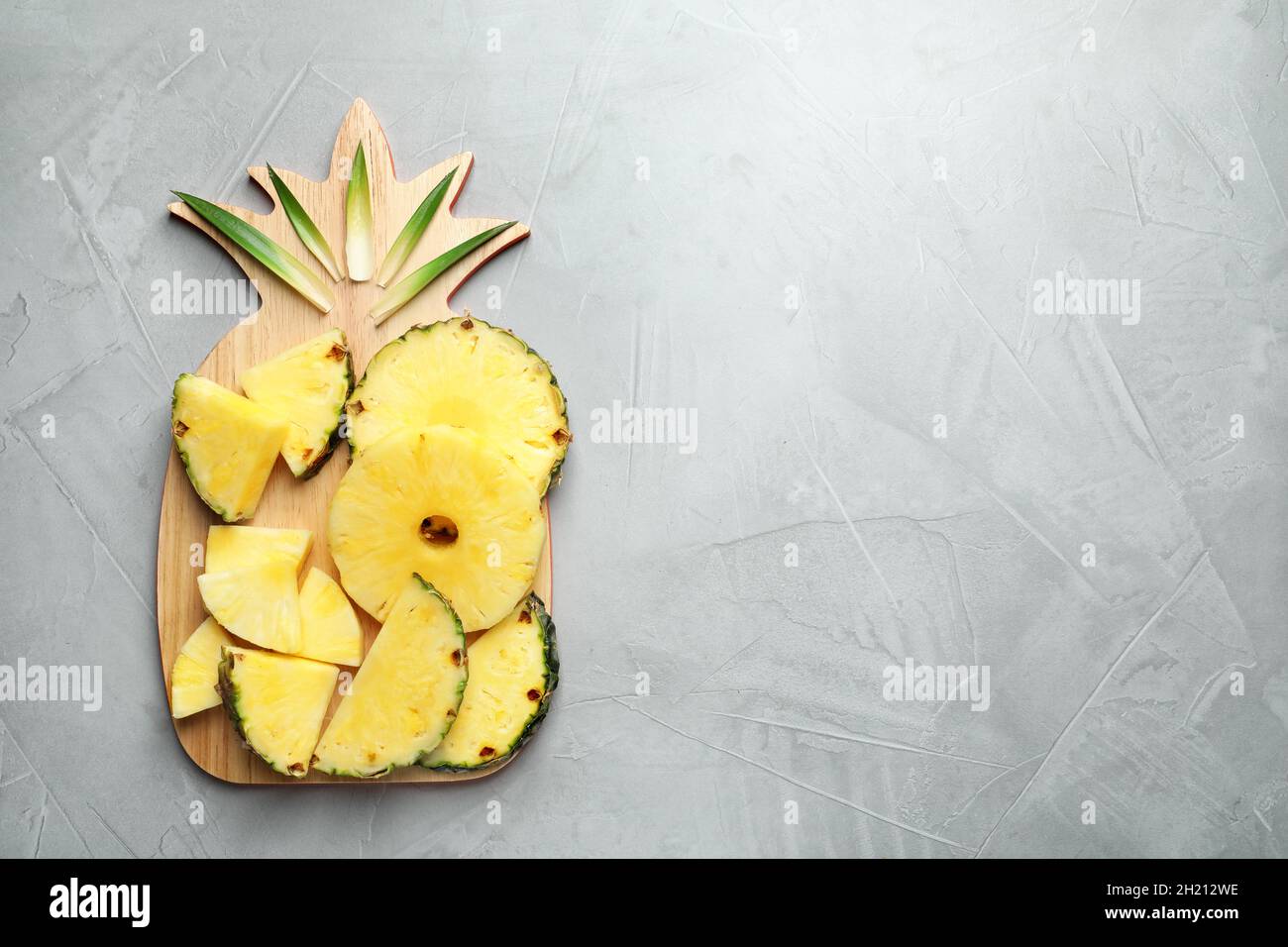 Flat lay composition with fresh sliced pineapple on gray background Stock Photo