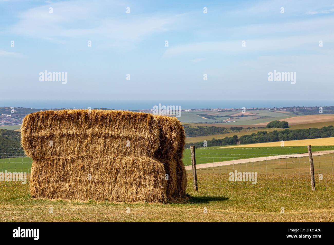 A haystack in a field in the South Downs, with the Sussex coast behind Stock Photo
