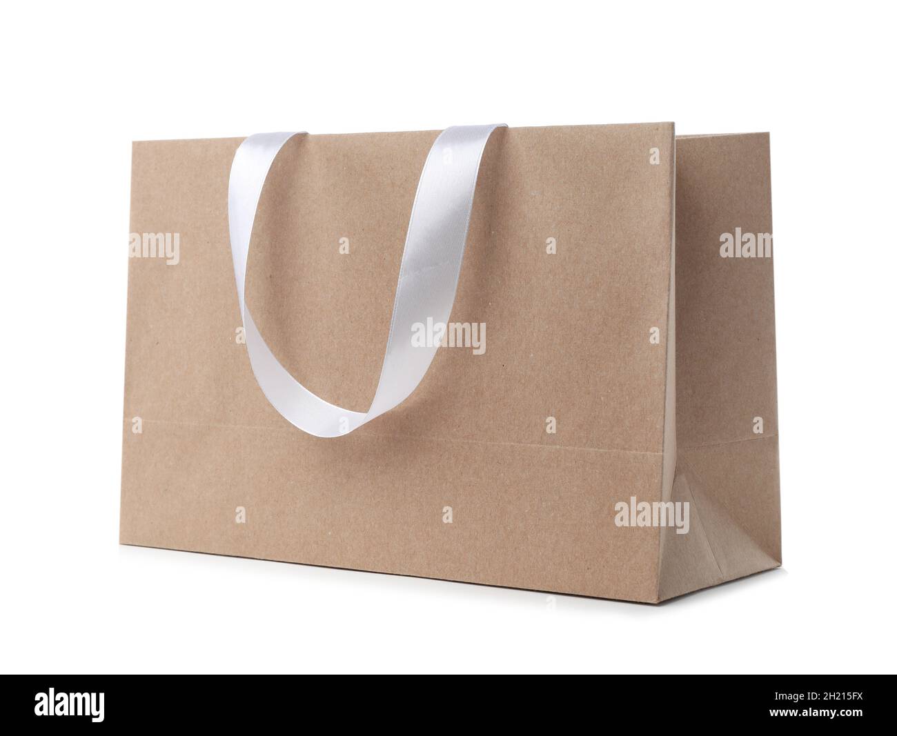 Paper shopping bag with ribbon handles on white background. Mockup for