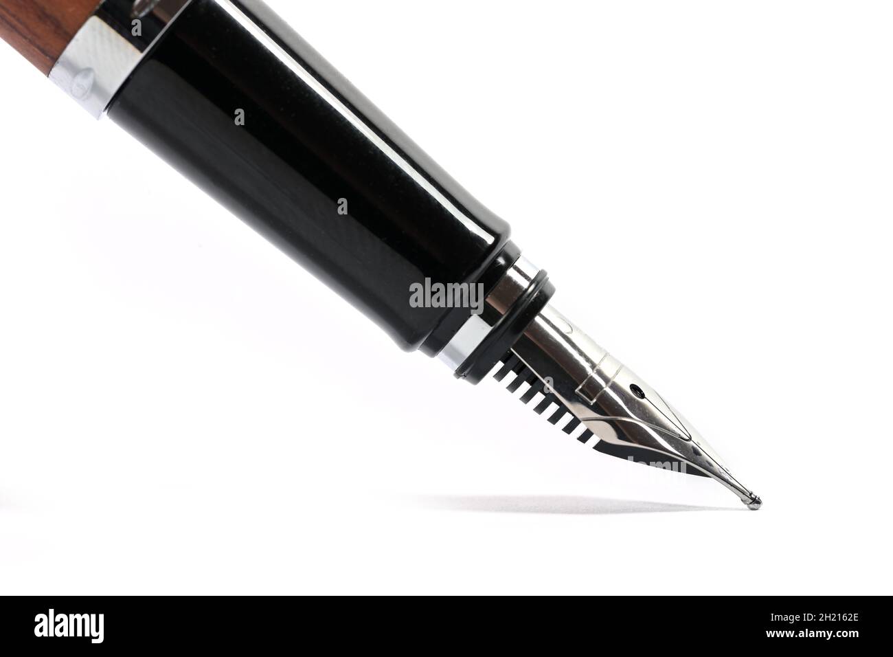 Detail of a fountain pen in black isolated with a small shadow on a white background, copy space, selected focus and narrow depth of field Stock Photo