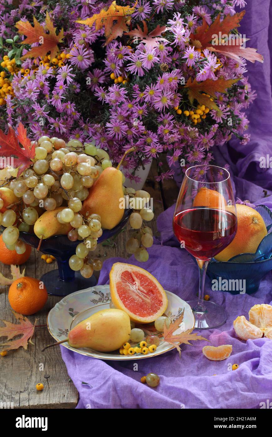 Still life with red wine, fruits and a bouquet of flowers Stock Photo ...