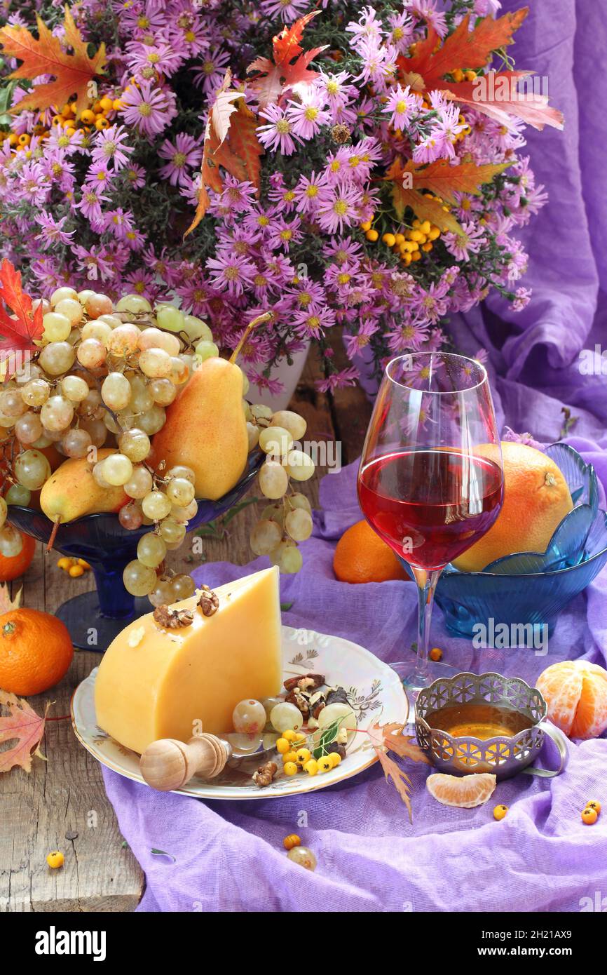 Still life with red wine, cheese, fruits and a bouquet of flowers Stock ...