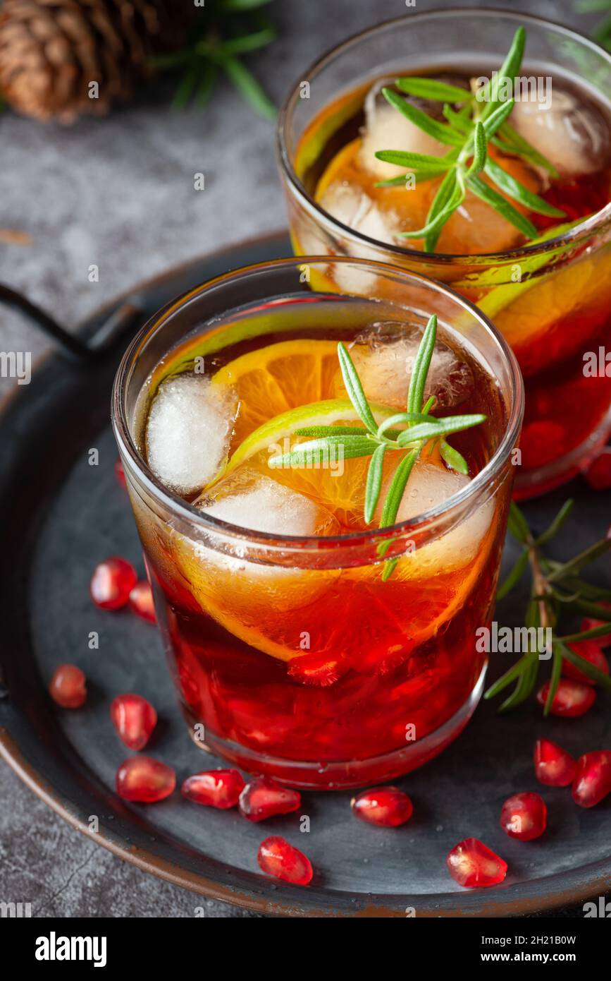 Pomegranate cocktail decorated with lime, rosemary and Ice, cold drink