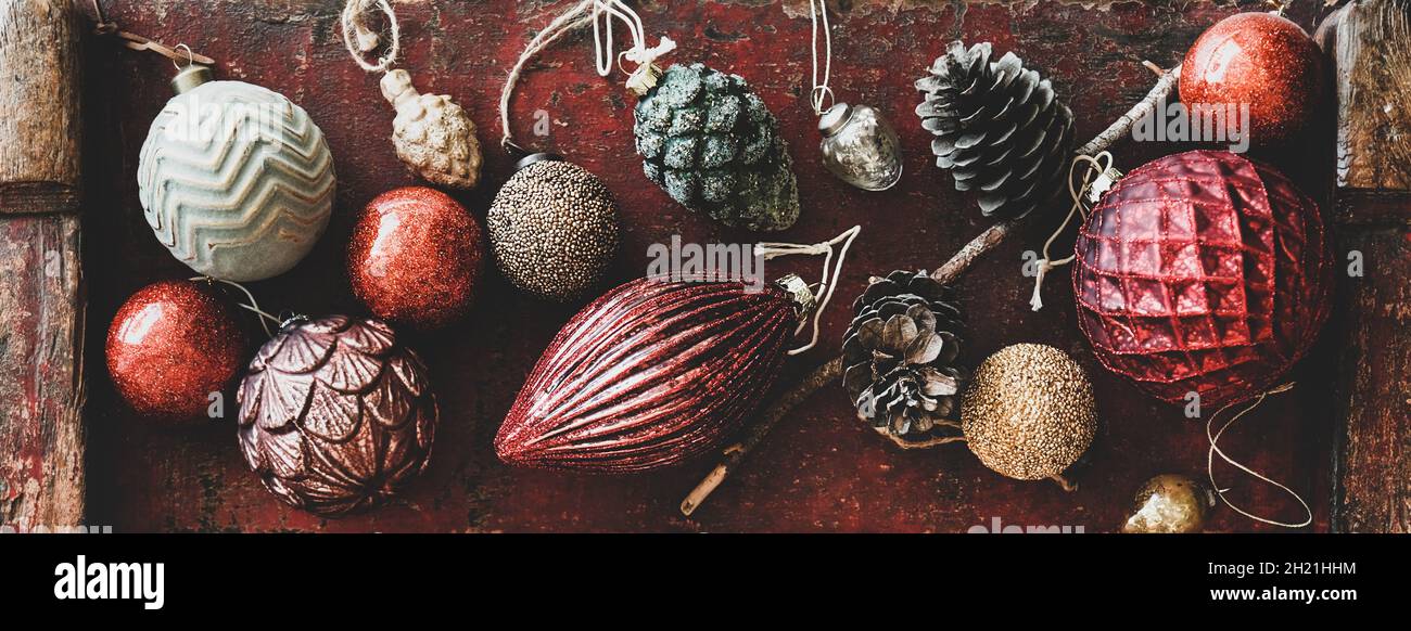 Flat-lay of Christmas decorative toys over red wooden background, close-up Stock Photo
