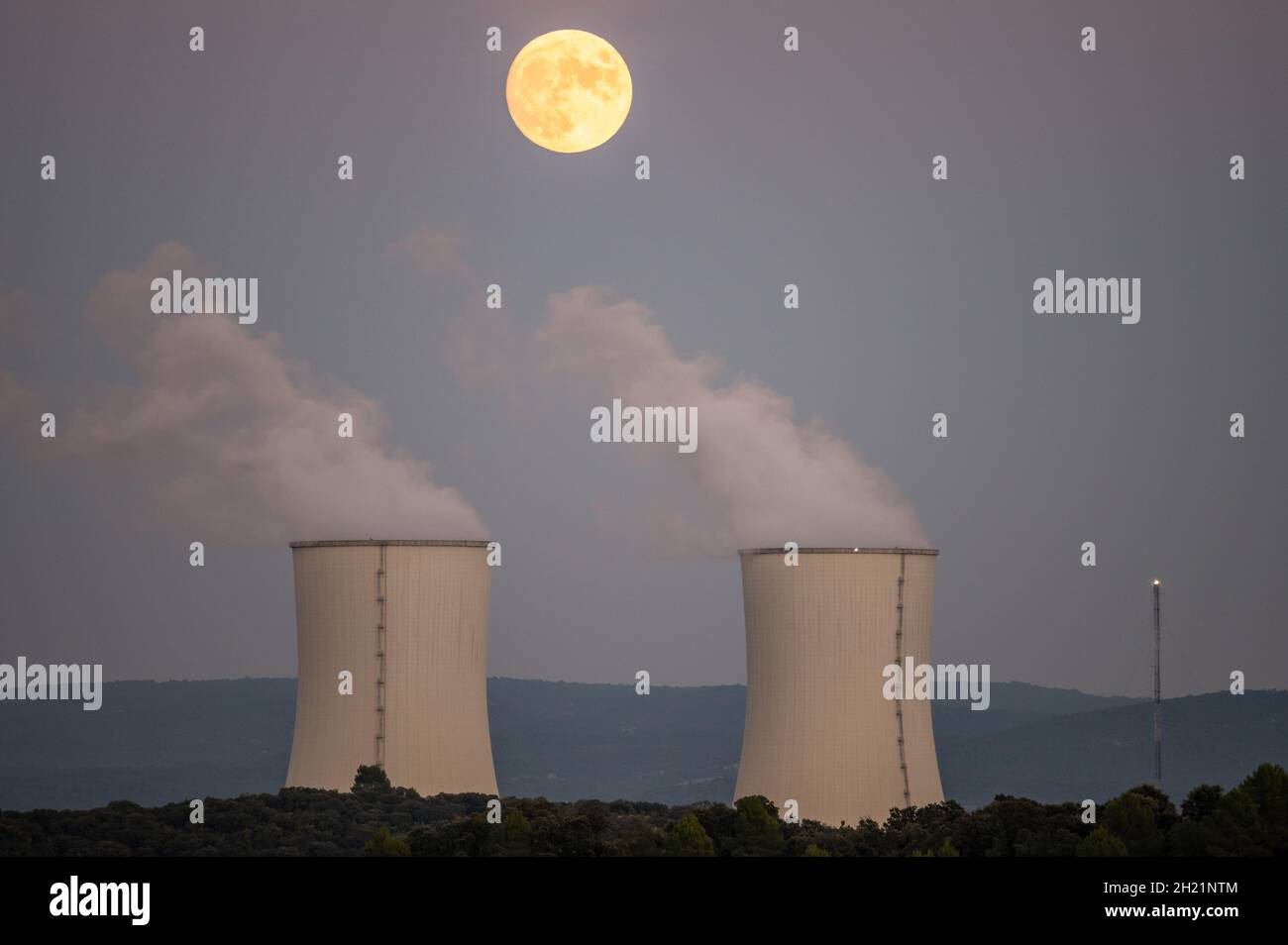 Trillo, Spain. 19th Oct, 2021. An almost full moon of October, known as Hunter's Moon, rises over the cooling towers of the Trillo Nuclear Power Plant. Credit: Marcos del Mazo/Alamy Live News Stock Photo