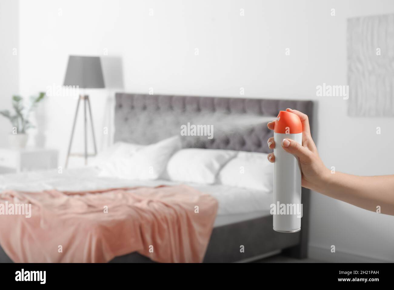 Woman spraying air freshener in bedroom Stock Photo Alamy