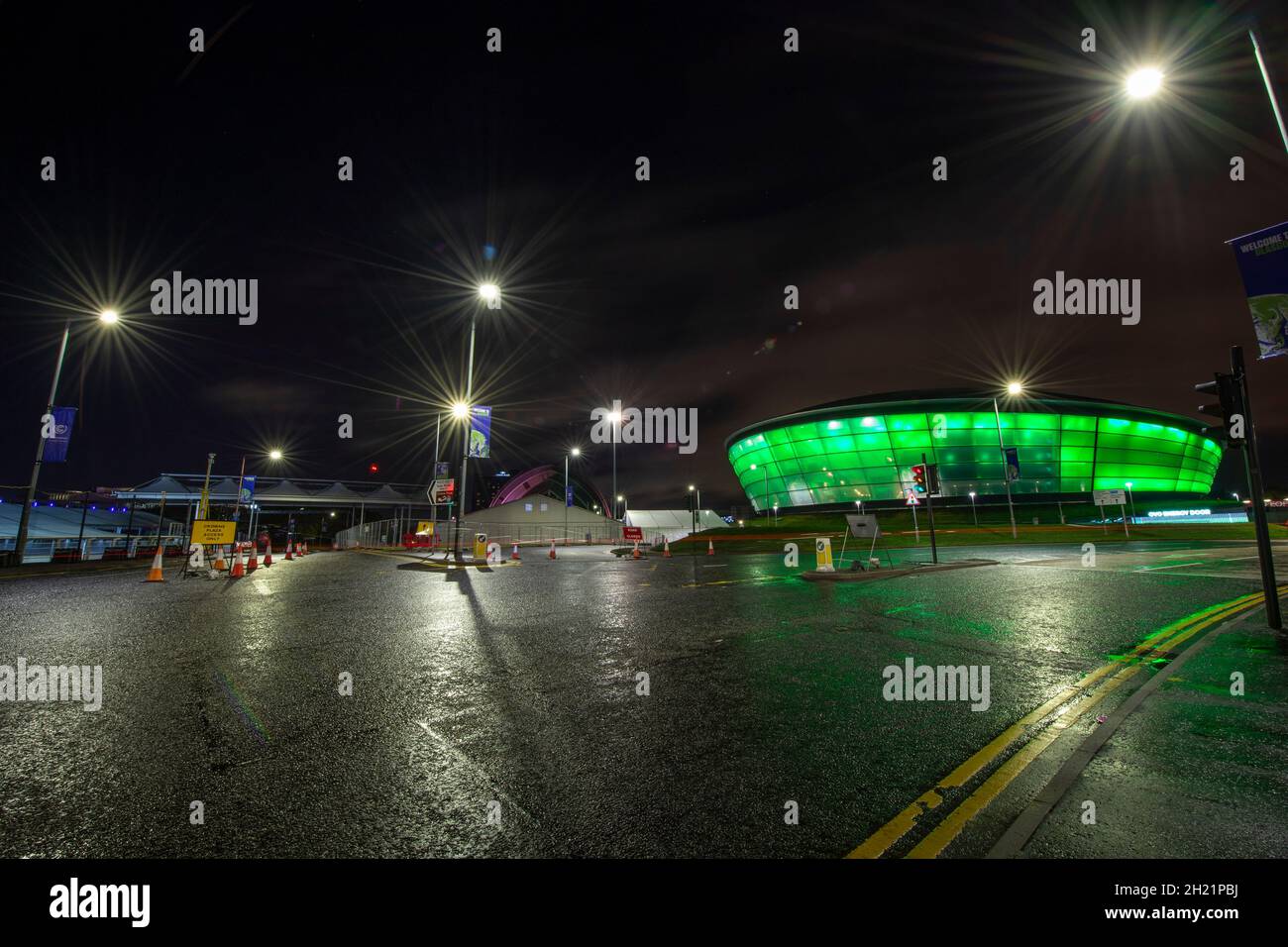 Glasgow, Scotland, UK. 19th Oct, 2021. PICTURED: Night views of the COP26 site and venue showing temporary structures half built on the grounds of the Scottish Event Campus (SEC) Previously known as Scottish Exhibition and Conference Centre (SECC) with the front car park outside of the newly named The OVO Hydro (formerly SSE Hydro) with new transfers over the walkway which says “People Make Glasgow” and night workers continue making preparations. Credit: Colin Fisher/Alamy Live News Stock Photo