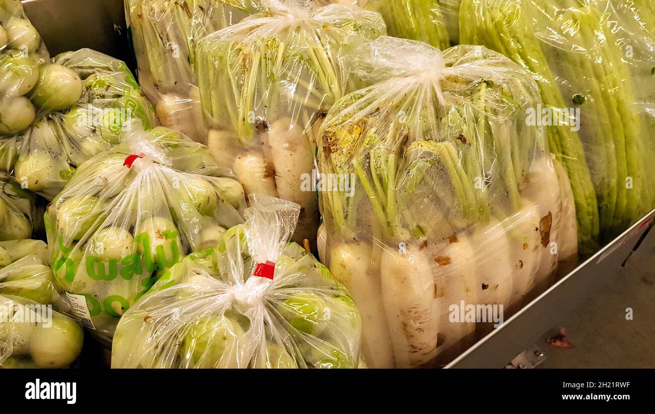 Vegetables are in plastic bags in shelves for sale. Stock Photo