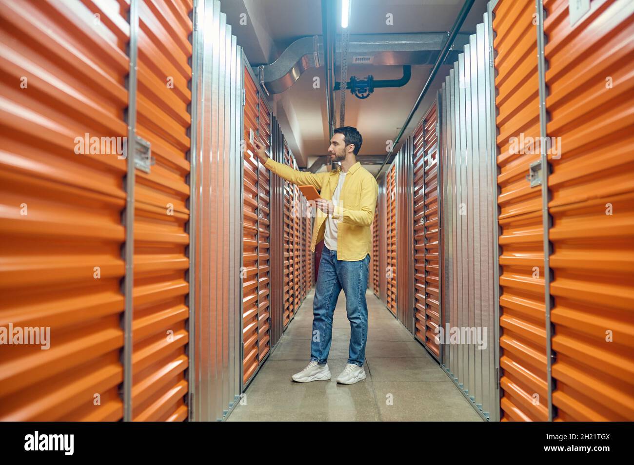 Man with tablet touching container door Stock Photo