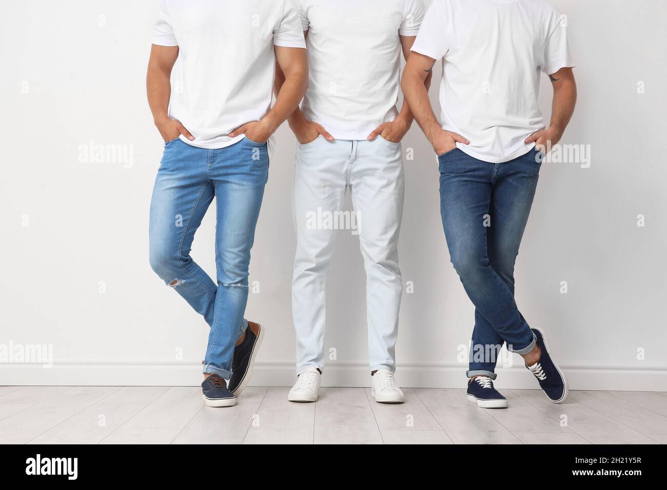 group-of-young-men-in-jeans-near-light-wall-stock-photo-alamy