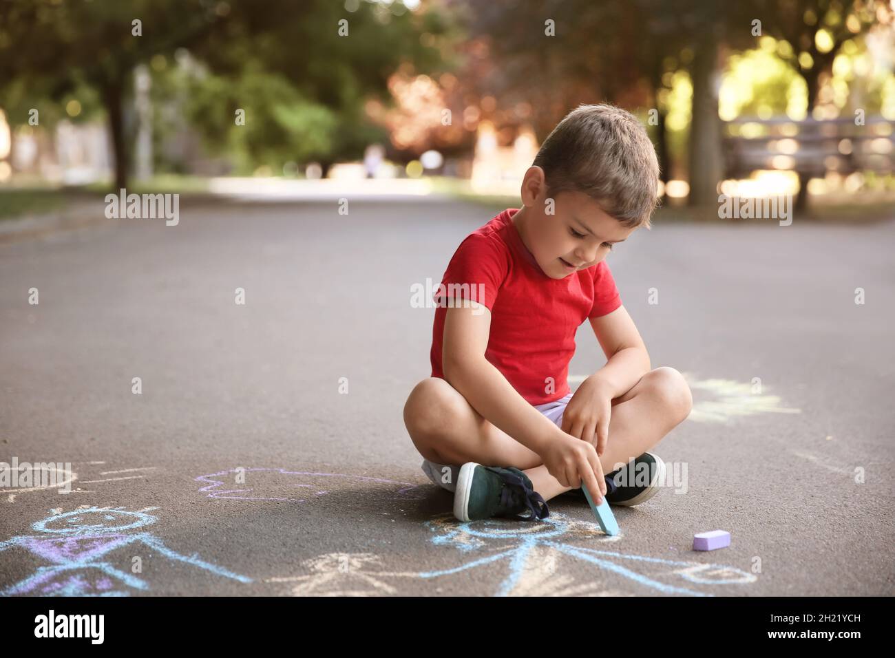 Little child drawing family with chalk on asphalt Stock Photo - Alamy