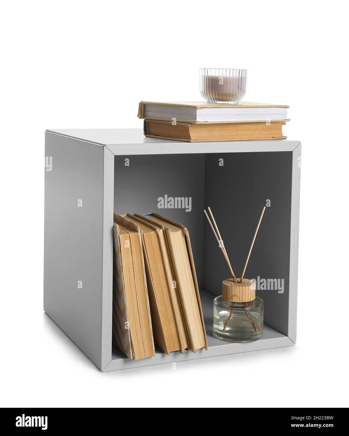 Small bookcase with reed diffuser and candle on white background Stock Photo Alamy