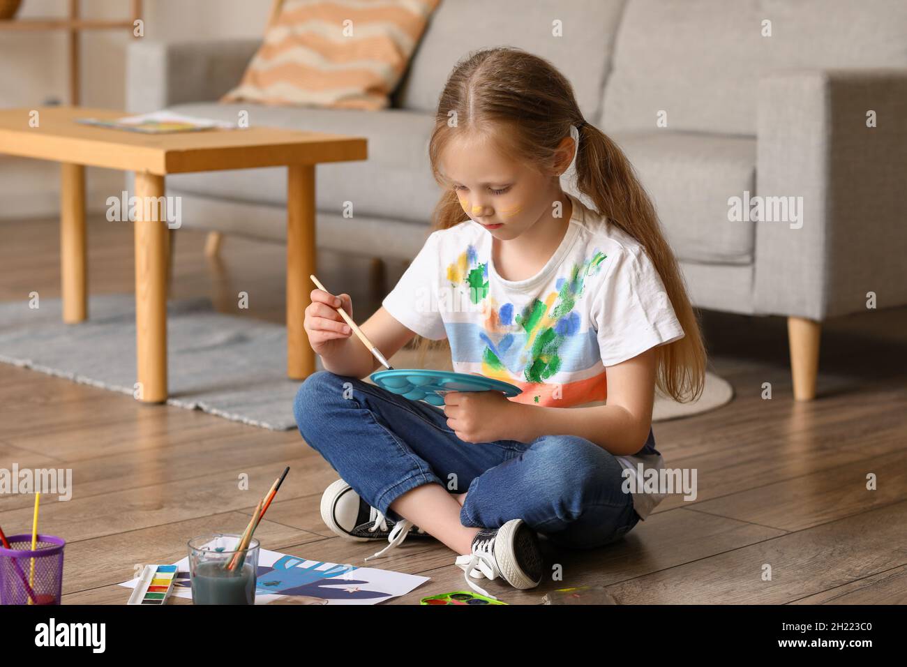 Little girl with brush and paint palette at home Stock Photo - Alamy