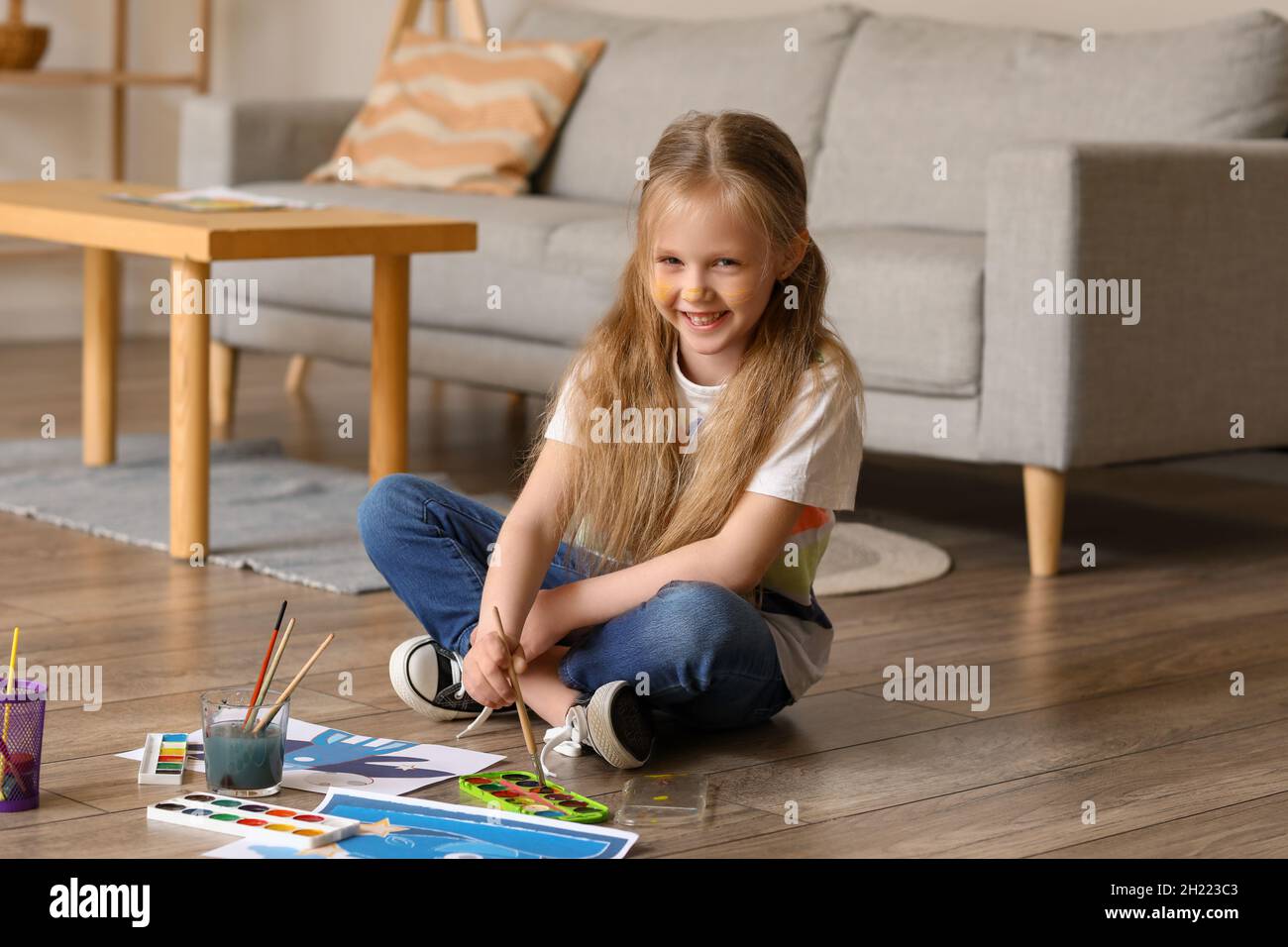 Little girl painting with watercolors on floor at home Stock Photo - Alamy