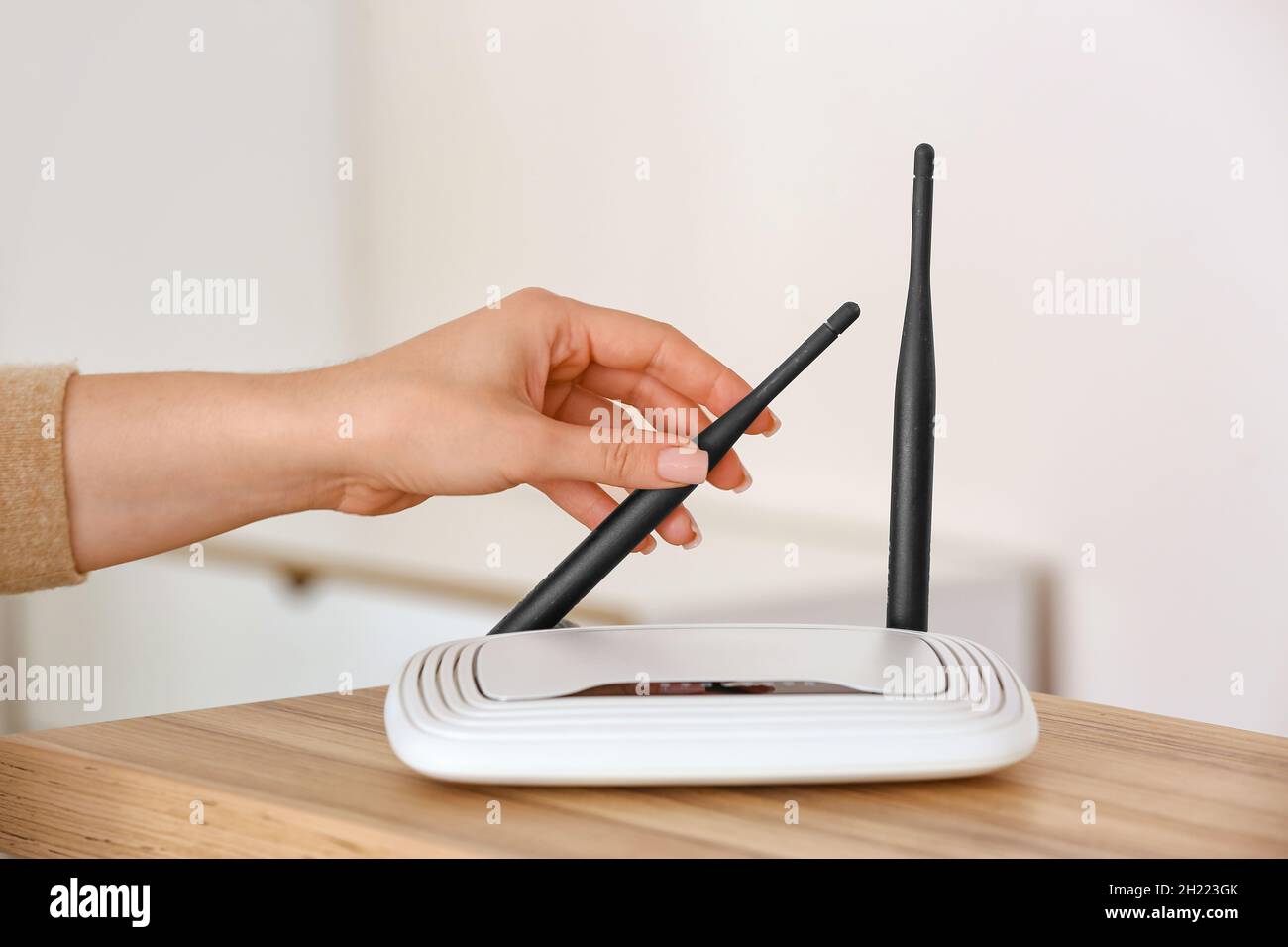 Female hand with wi-fi router on table in room Stock Photo - Alamy