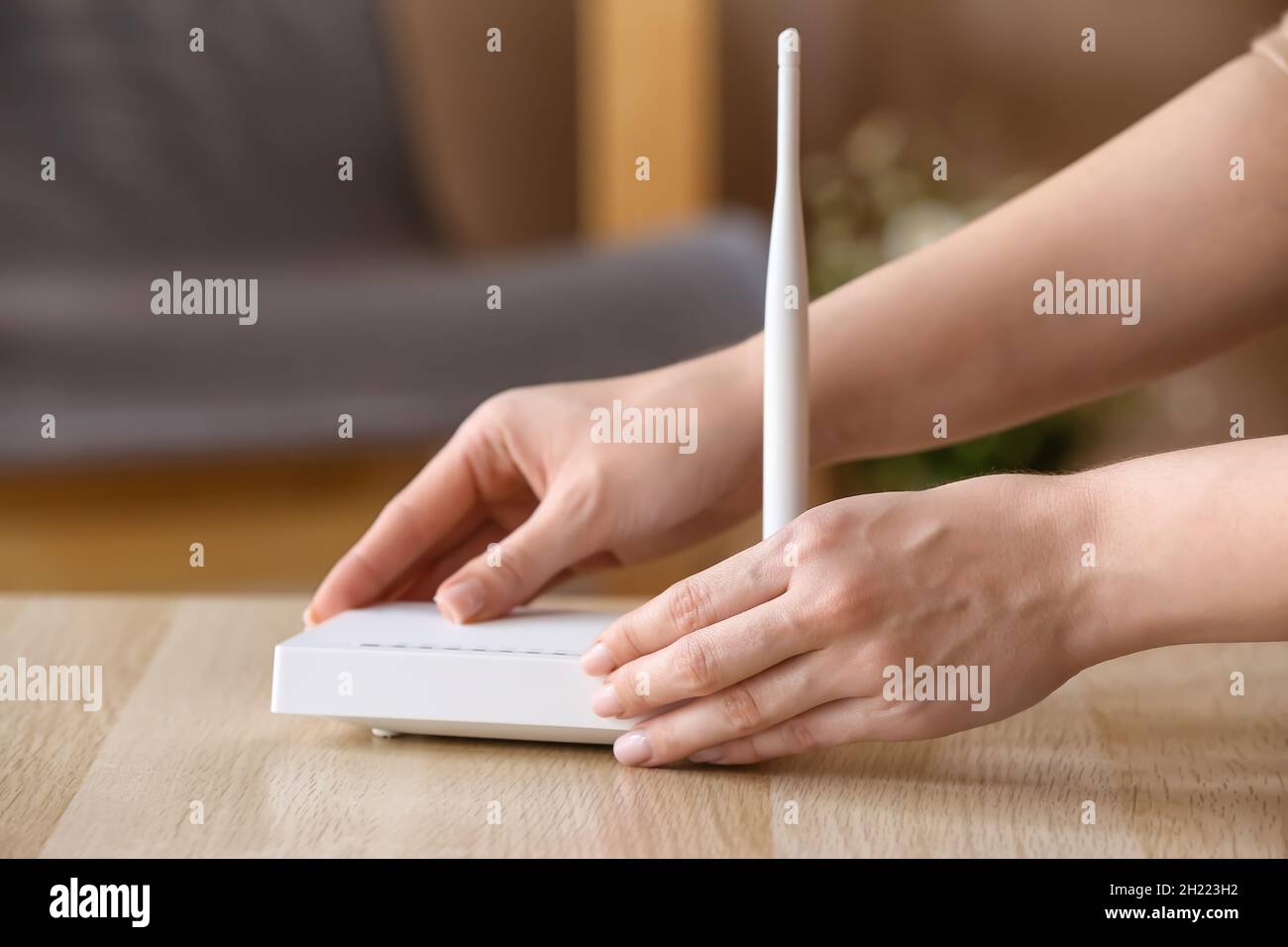 Female hand with wi-fi router on table in room Stock Photo - Alamy
