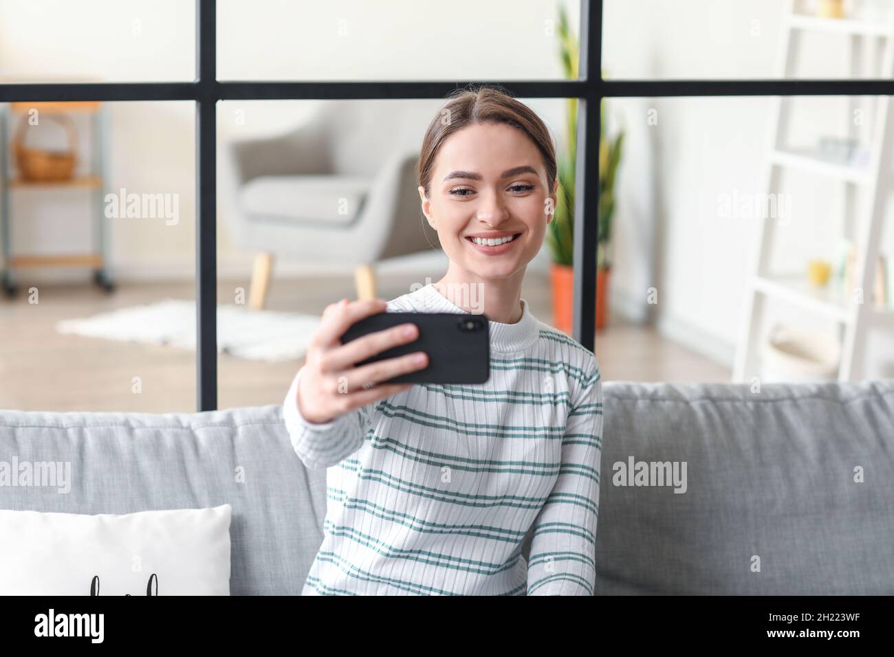 Pretty young woman taking selfie at home Stock Photo - Alamy
