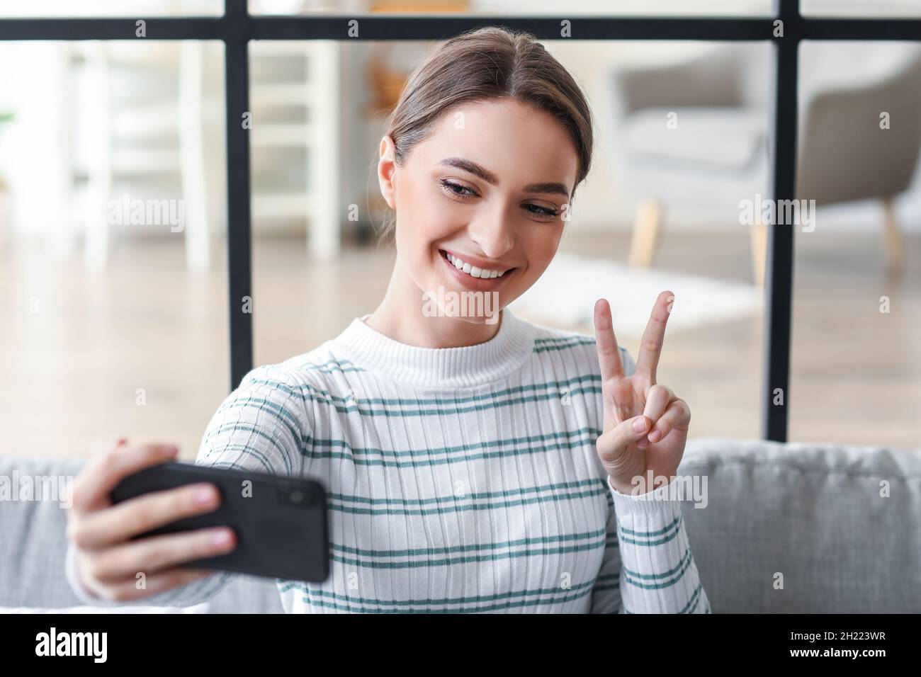 Pretty young woman taking selfie at home Stock Photo - Alamy