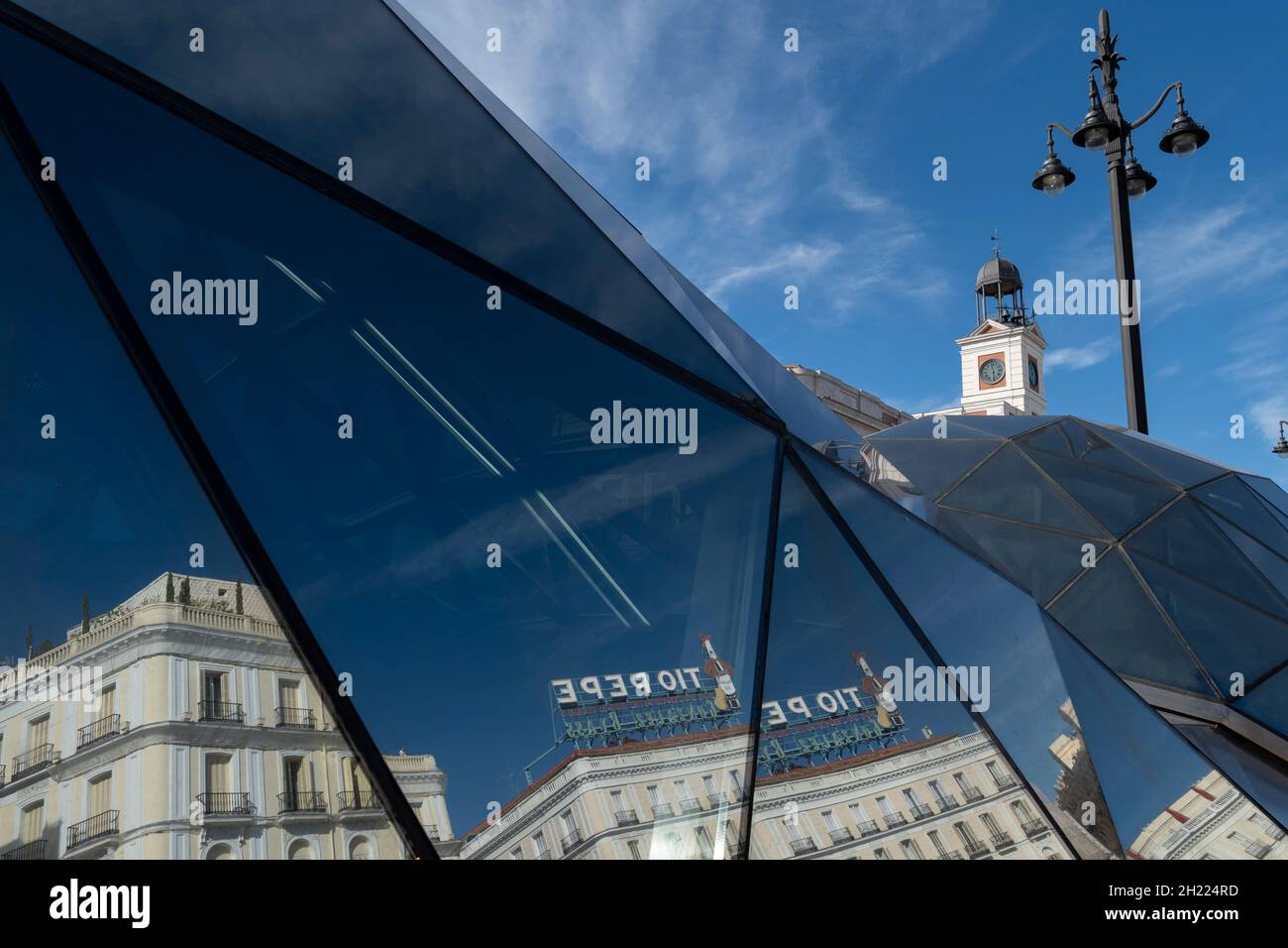 The landmark Tío Pepe sign is reflected in the modern facade of the Sol metro station in the Puerta del Sol in Madrid, Spain. The station was part of Stock Photo
