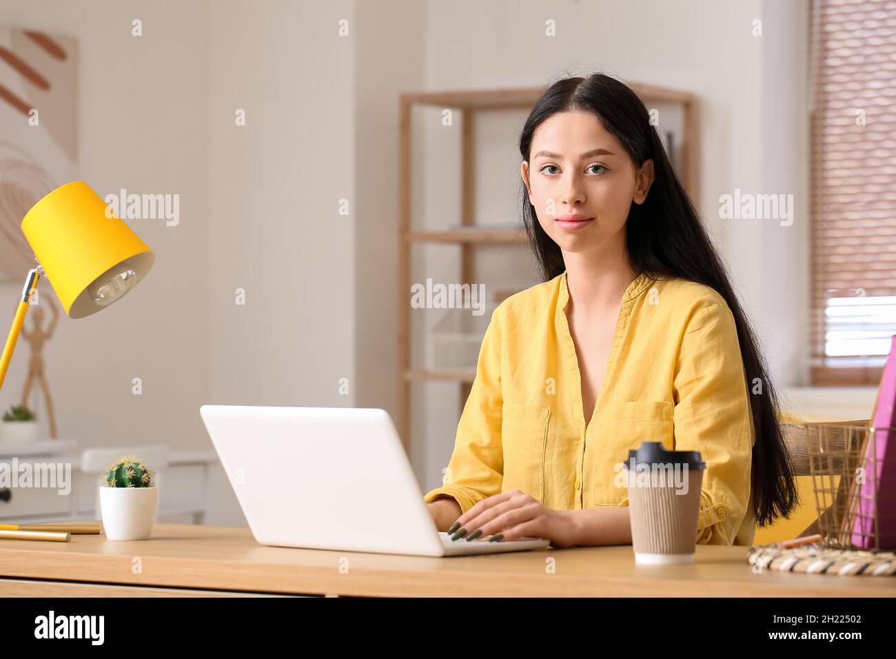 Beautiful teenage girl using laptop at table Stock Photo - Alamy