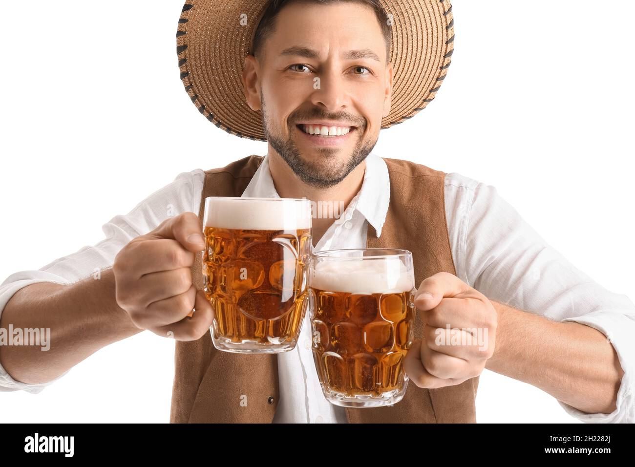 Young man in traditional German clothes with beer on white background
