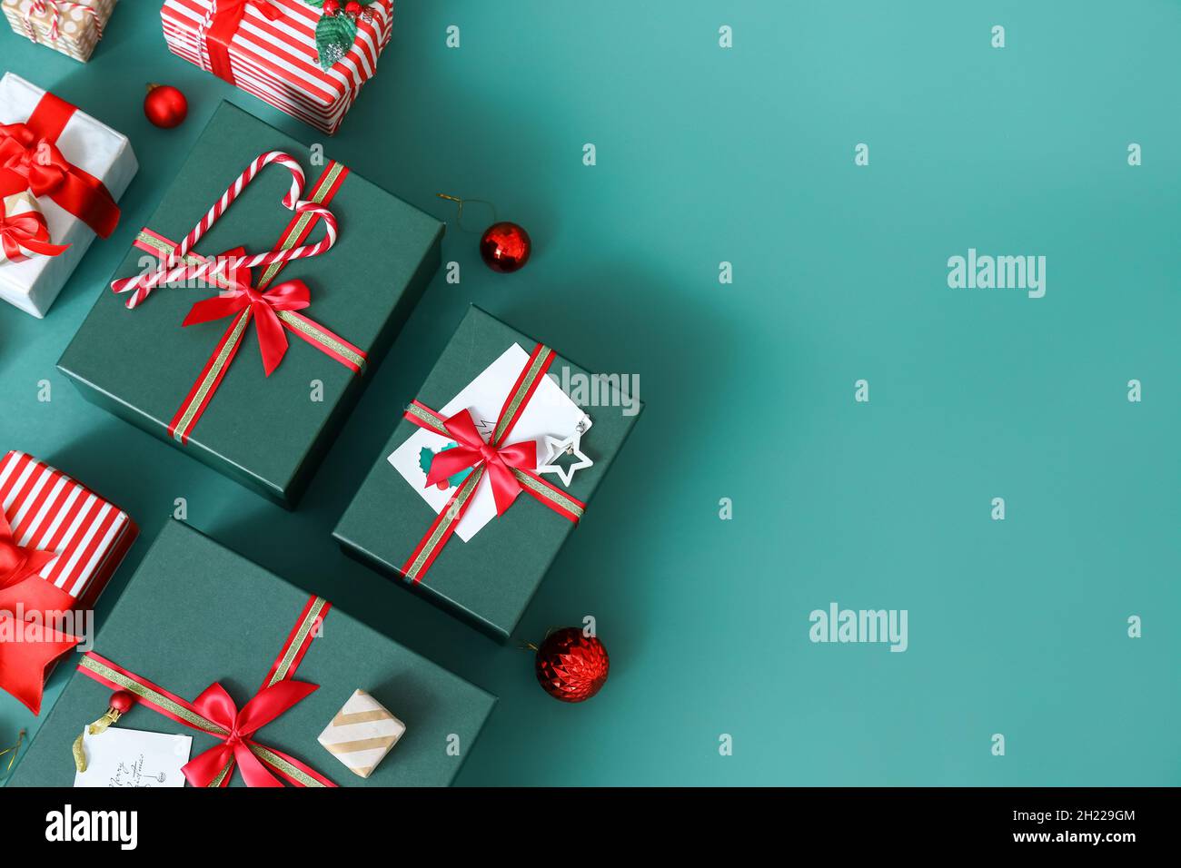 Christmas gift boxes with candy canes and balls on green background ...