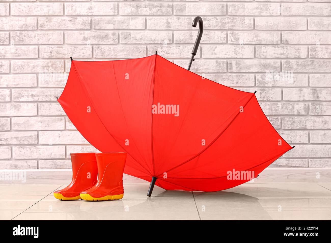 Pair of rubber rain boots and umbrella near brick wall Stock Photo Alamy