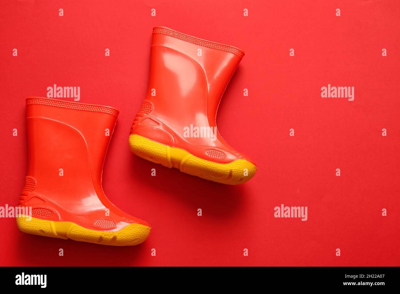 Pair of rubber boots on red background Stock Photo Alamy