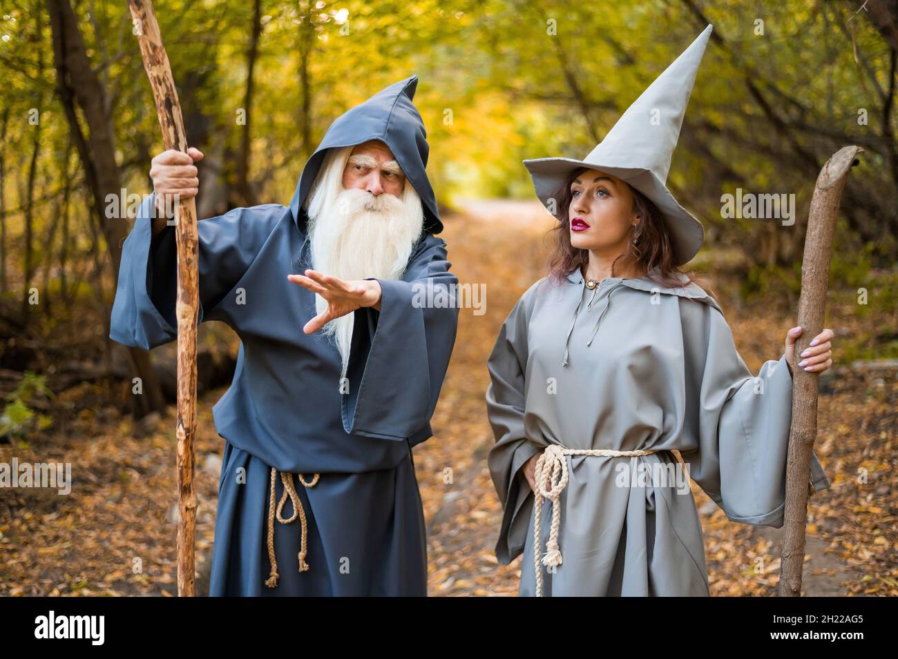 Wizard and sorceress in the autumn forest. Elderly man and woman in  carnival costumes for halloween Stock Photo - Alamy
