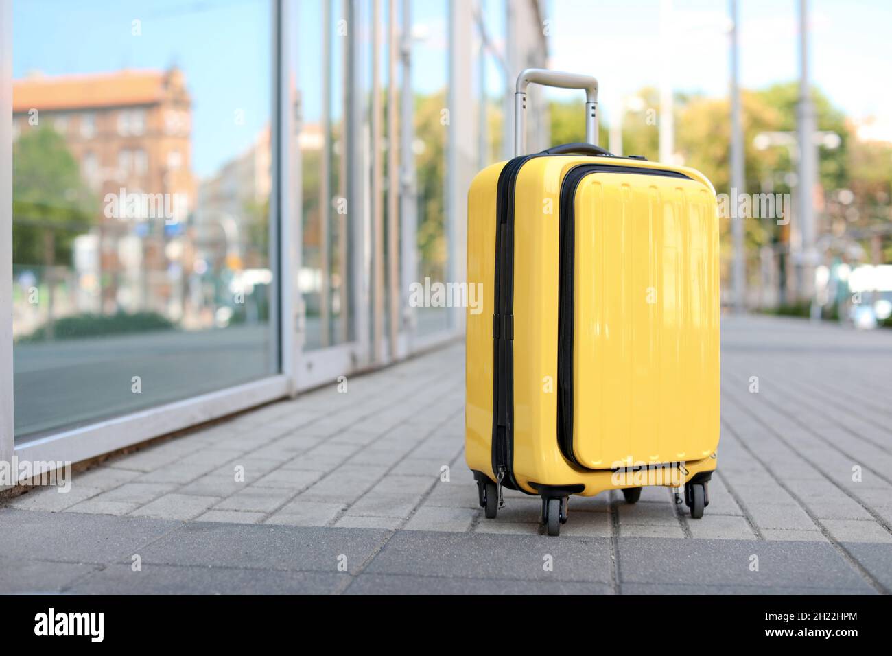 Packed yellow carry on suitcase on city street Stock Photo Alamy