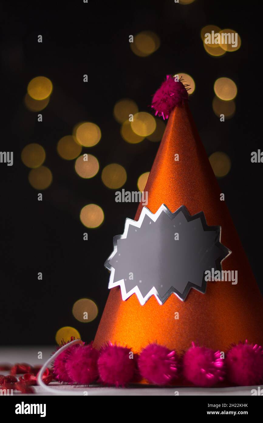 party hat on a blurred black background, cone shaped, design template with space for text, taken in shallow depth of field, mockup Stock Photo