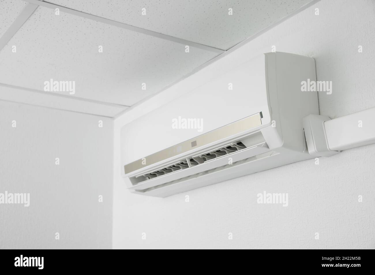 Modern air conditioner on white wall indoors Stock Photo - Alamy